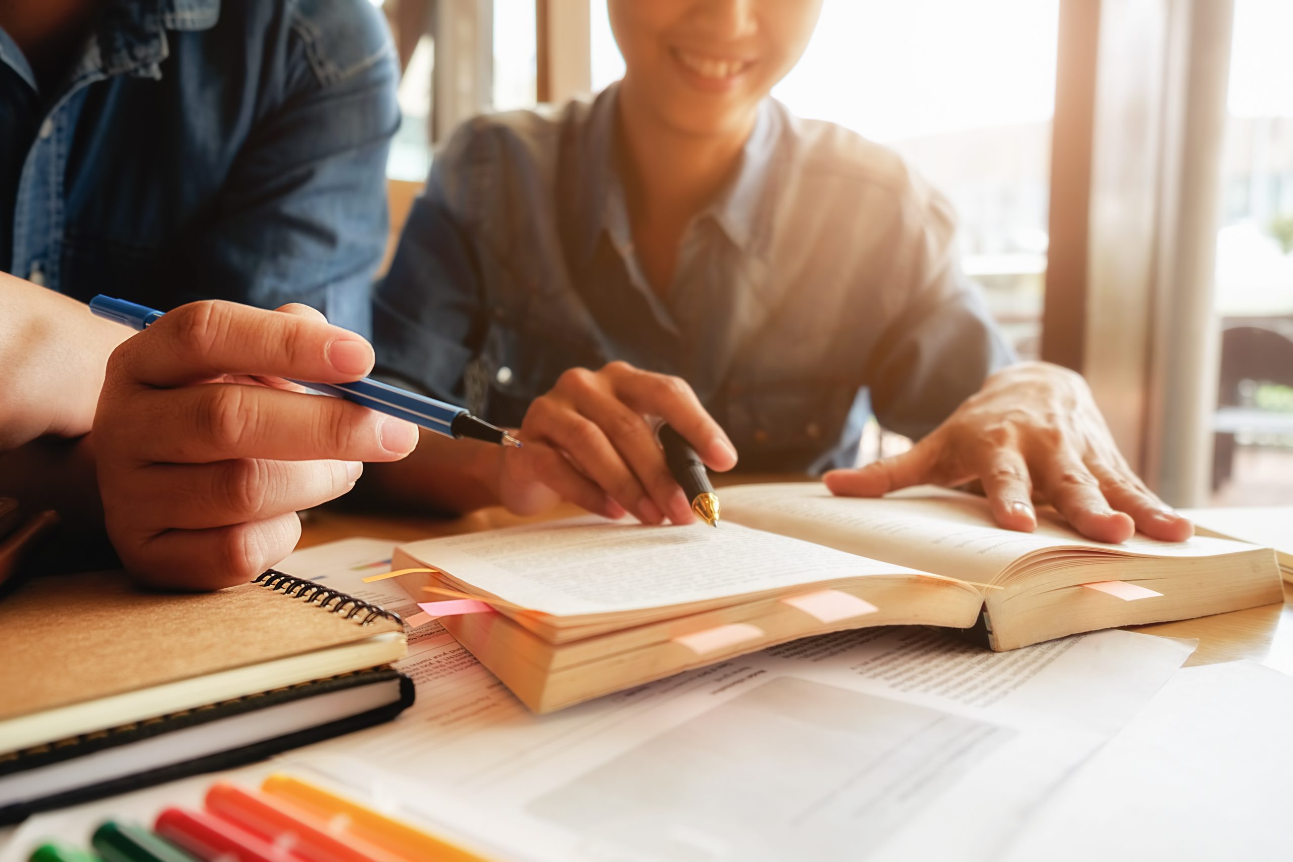 education-concept-student-studying-brainstorming-campus-concept-close-up-students-discussing-their-subject-books-textbooks-selective-focus-scaled